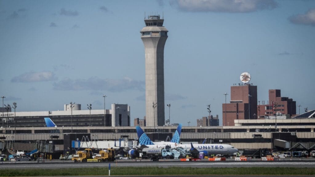 Airport control tower with United Airlines plane.