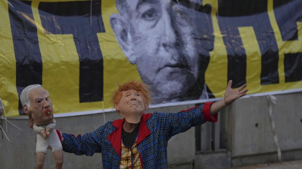 Protester with masks in front of banner.