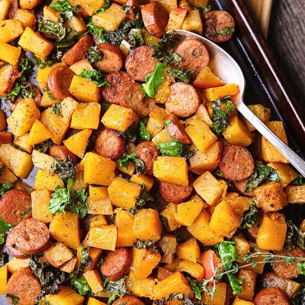 Chicken sausage and butternut squash sheet pan meal sitting on a table top.