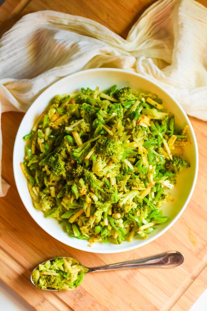 healthy broccoli salad dressed in a poppy seed dressing served in a white dish.