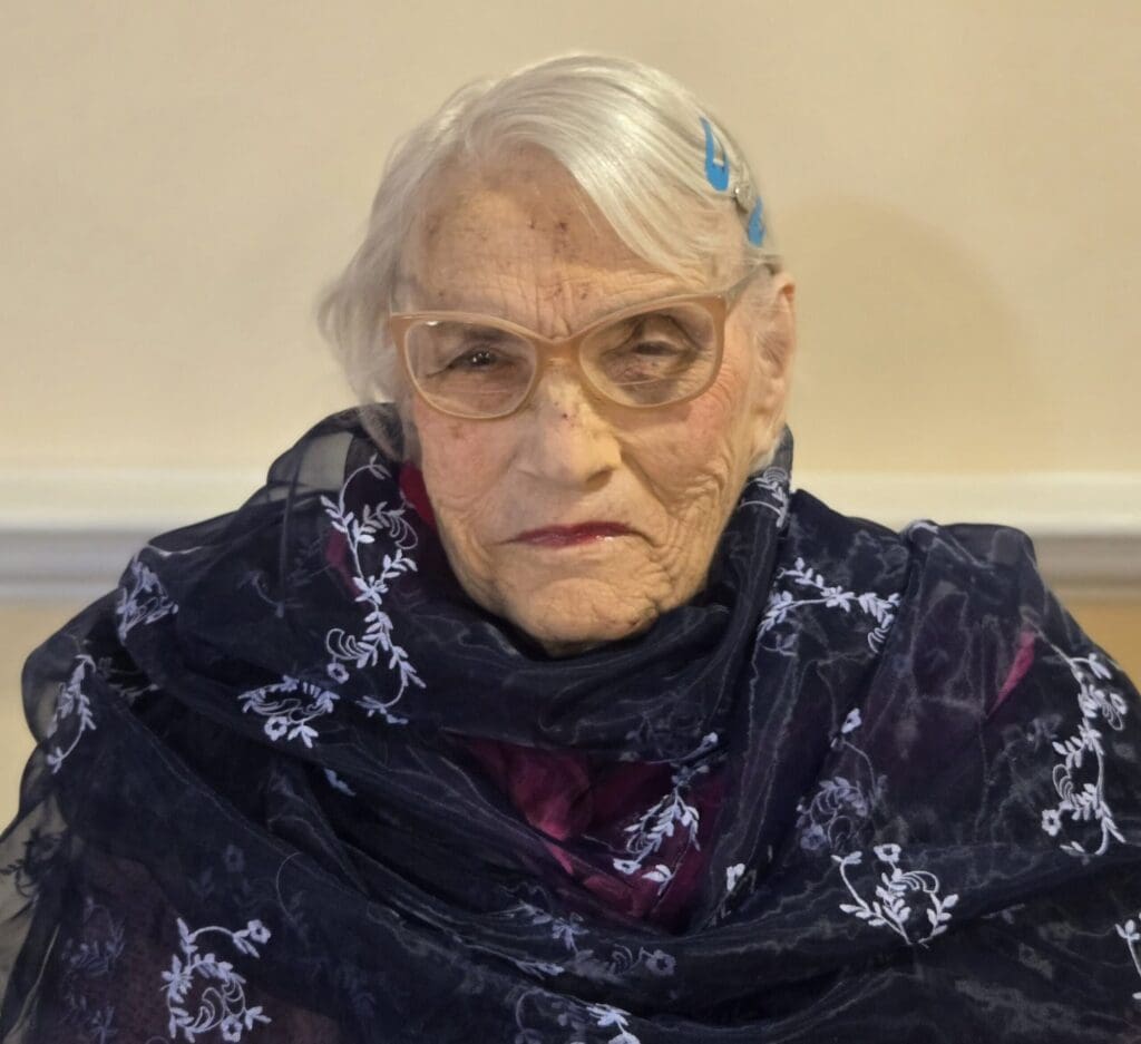 Centenarian woman in dark blue and light floral shawl