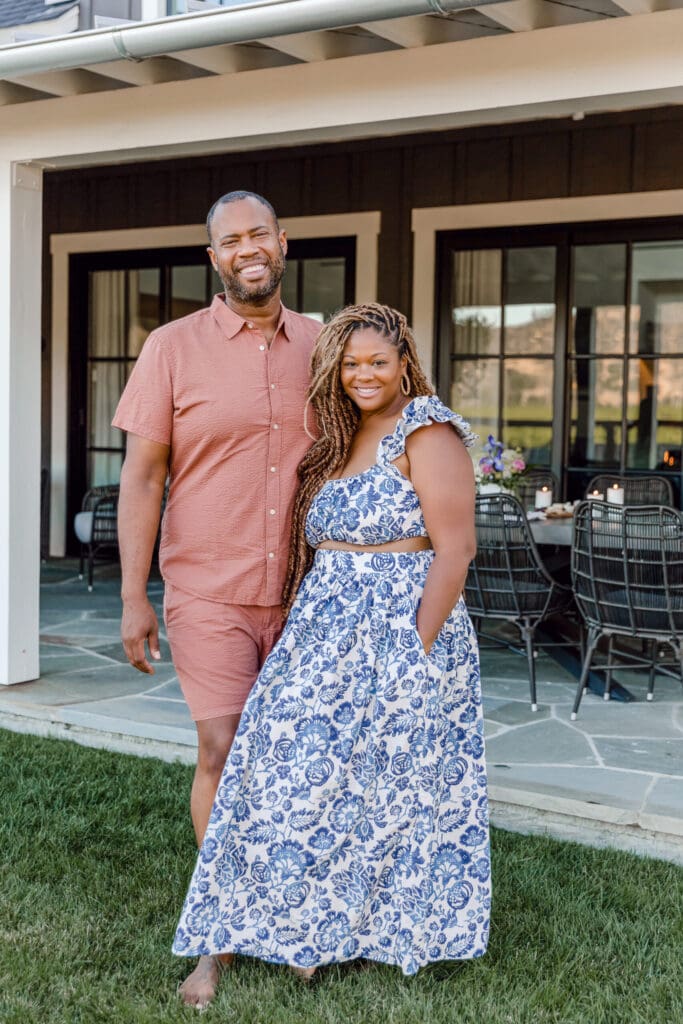 Couple smiling outside a house on patio.