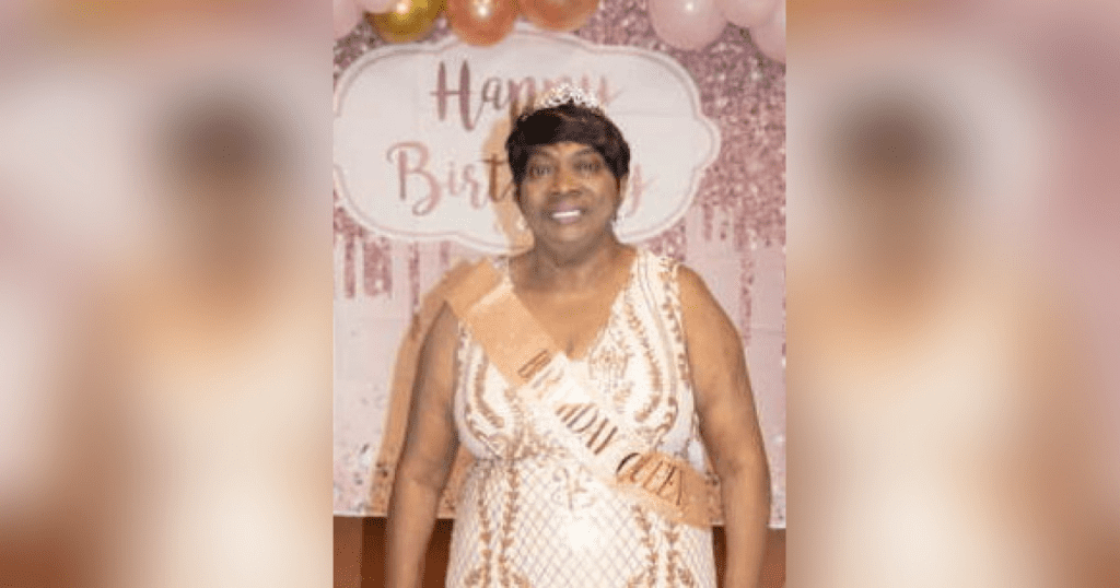 Woman celebrating birthday with festive backdrop.