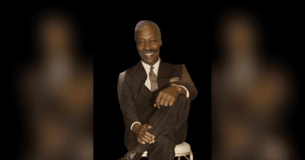 Man in suit sitting on a chair.