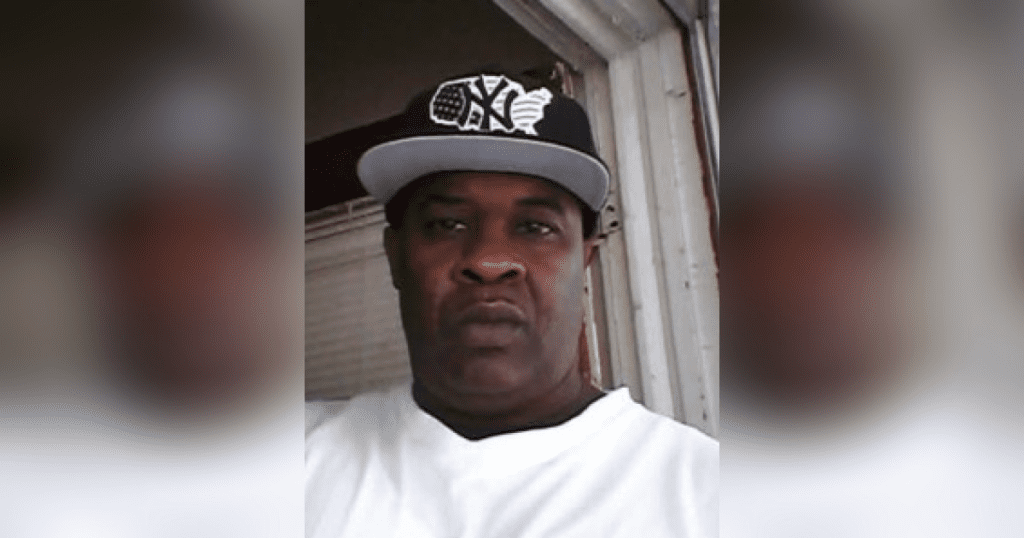 Man wearing a cap and white shirt.