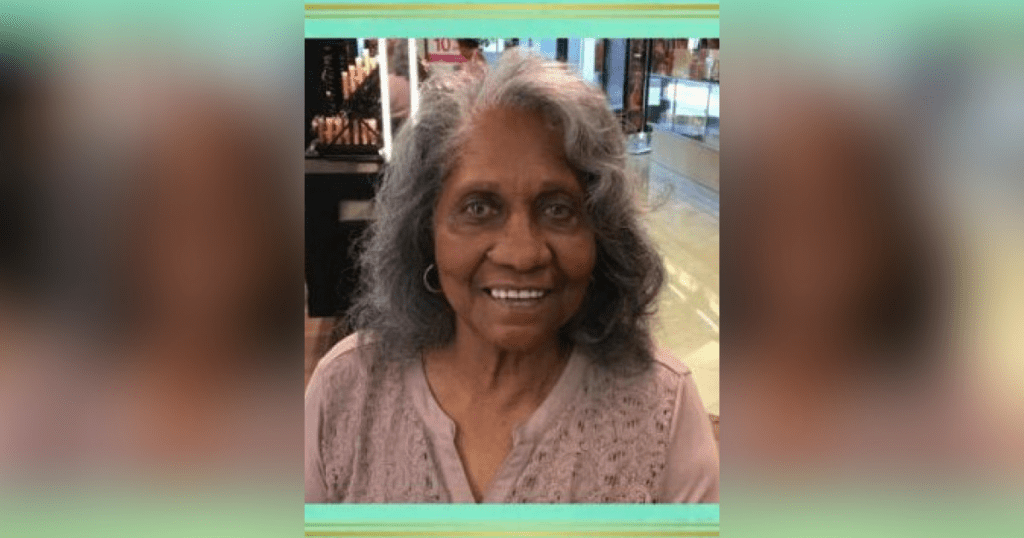 Smiling woman with gray hair indoors.