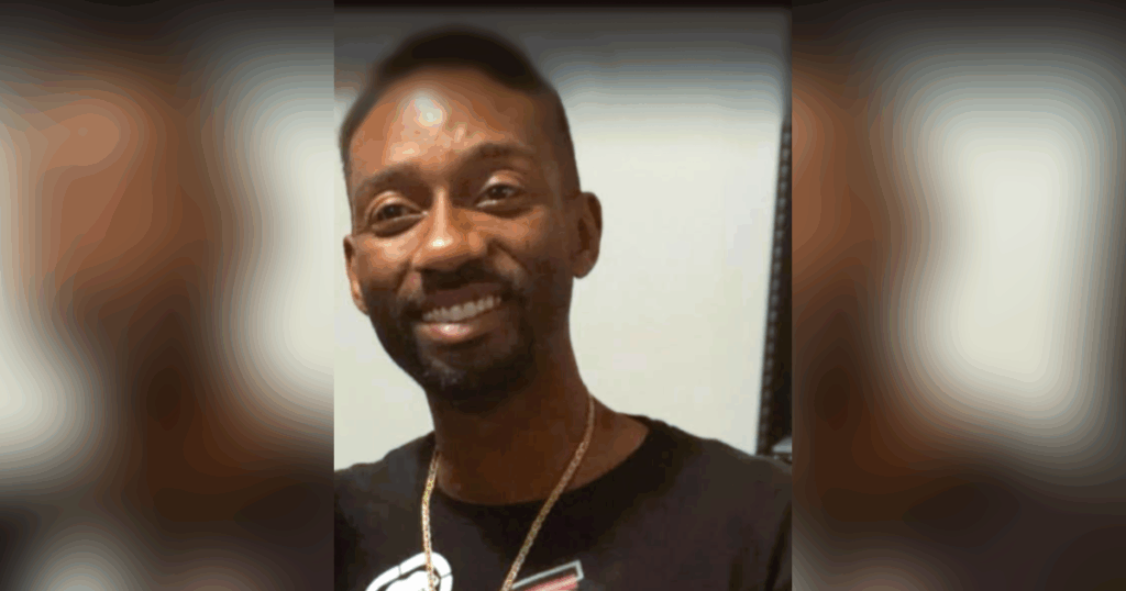 Smiling man wearing a black shirt.
