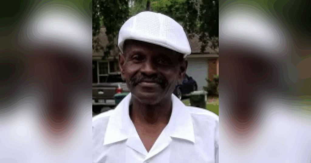Man in white hat and shirt outdoors.