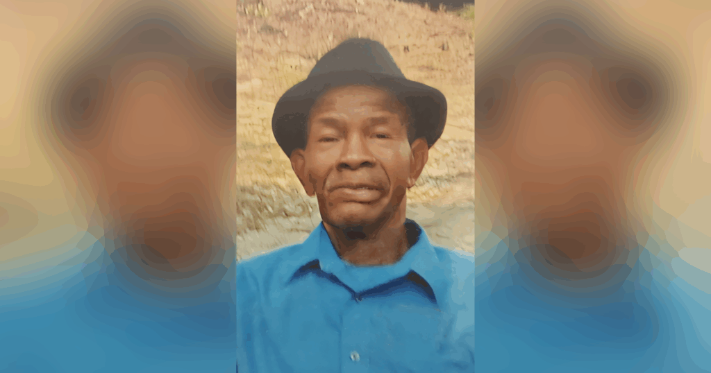 Elderly man wearing a hat and blue shirt.