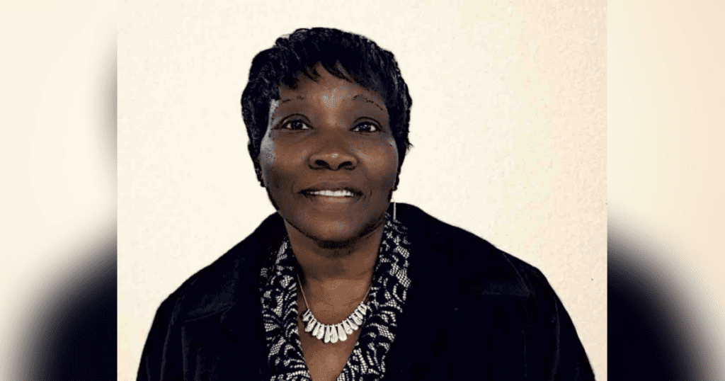 Smiling person wearing a necklace and jacket.