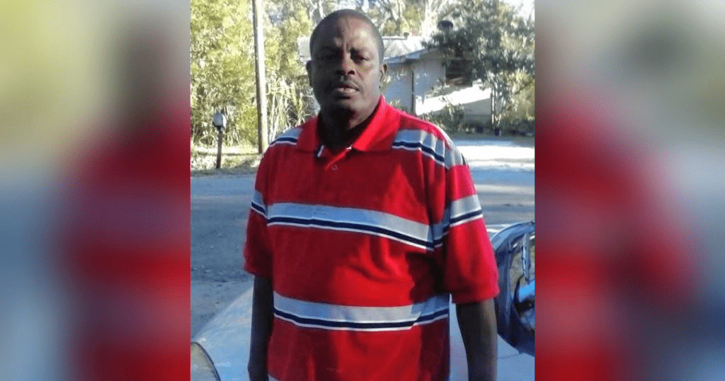 Man in red striped shirt outdoors.