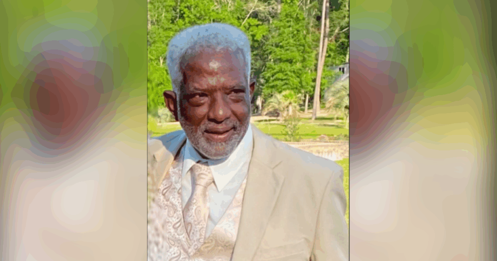 Elderly man in beige suit outdoors.