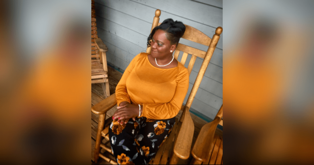 Woman sitting on a wooden rocking chair.