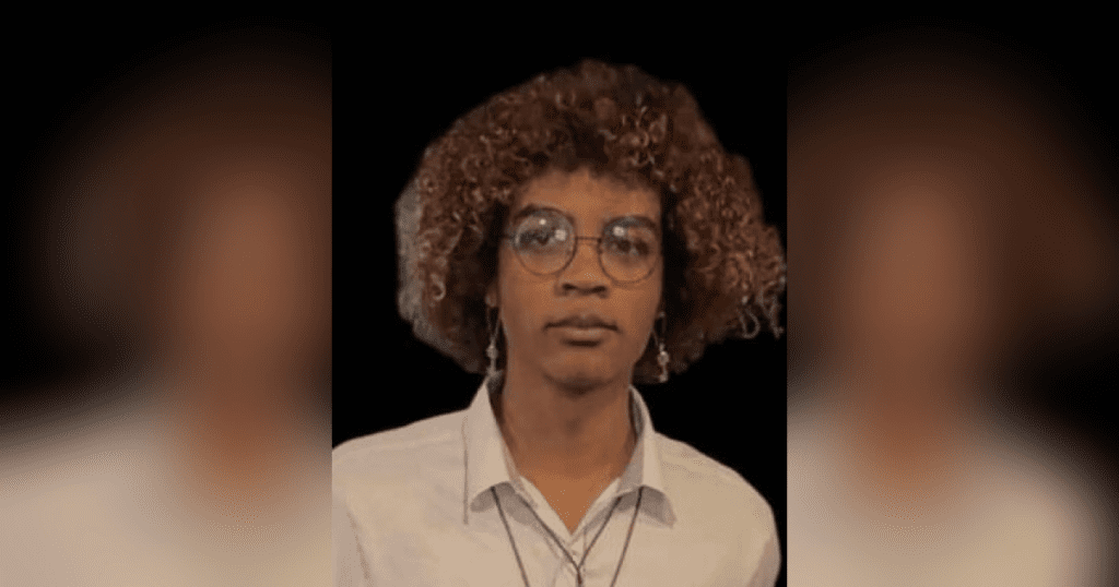 Person with curly hair and glasses.