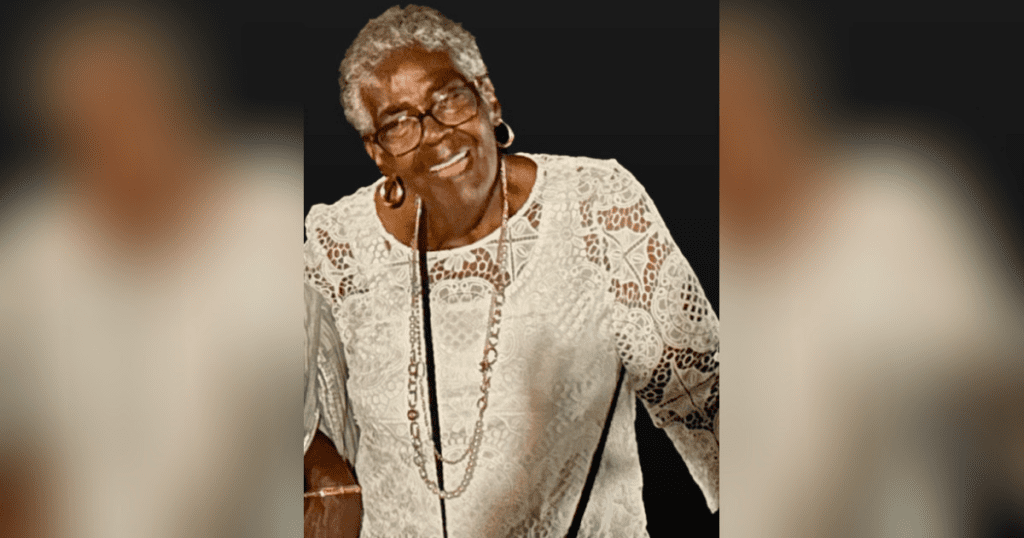 Smiling elderly woman in lace blouse.