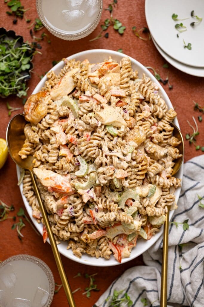 Best Seafood Salad Recipe on a platter with serving spoons and a drink.