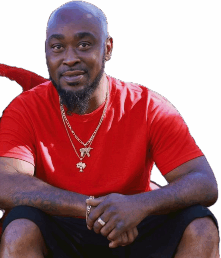 Man in red shirt sitting and smiling.