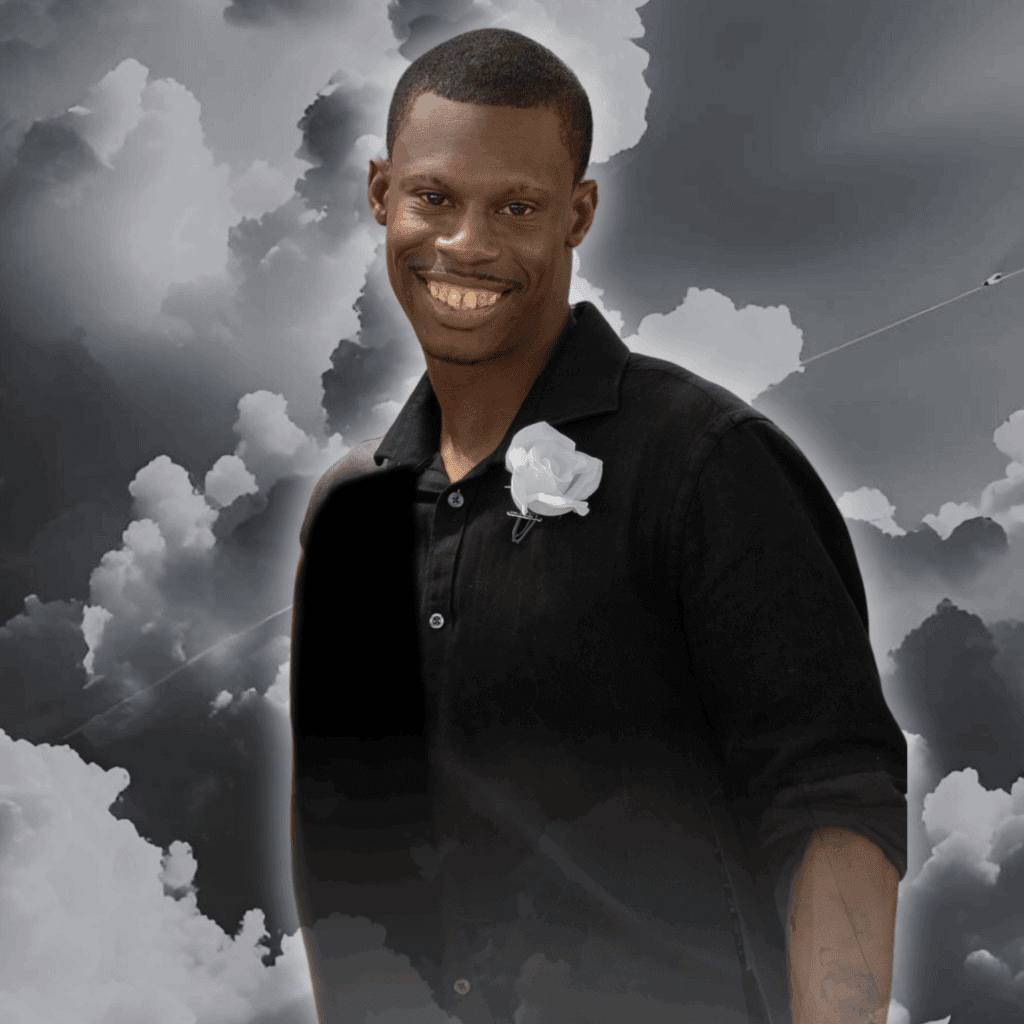 Man smiling against cloudy sky background.