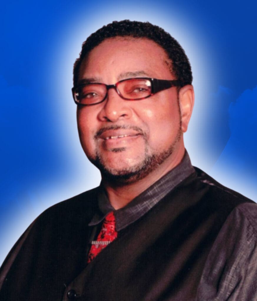 Smiling man with glasses against blue background.