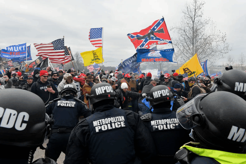 HBCU News – Justice Department Hires Jan.6th Rioter Protest with police, flags, and large crowd.