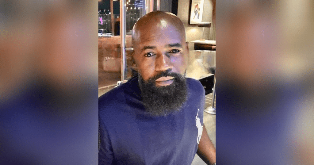 Man with beard in a restaurant setting.