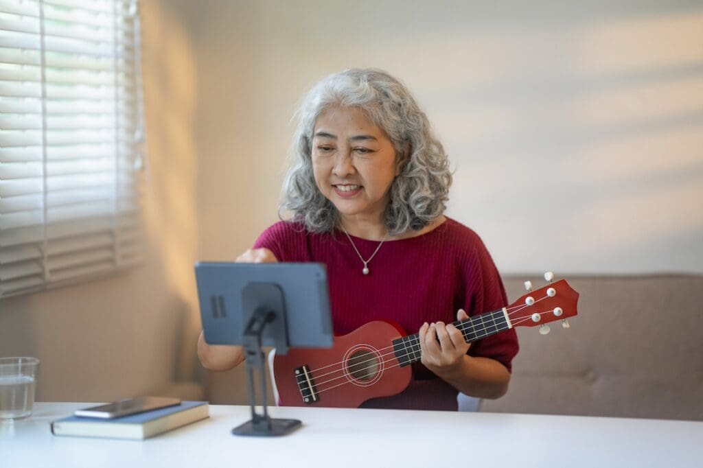 senior woman practices her musical skills at home with app