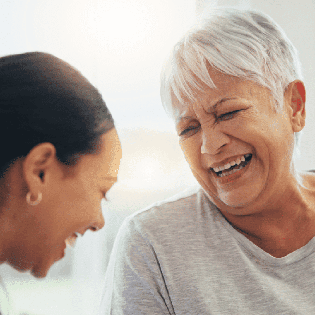 Senior woman laughing with her caregiver