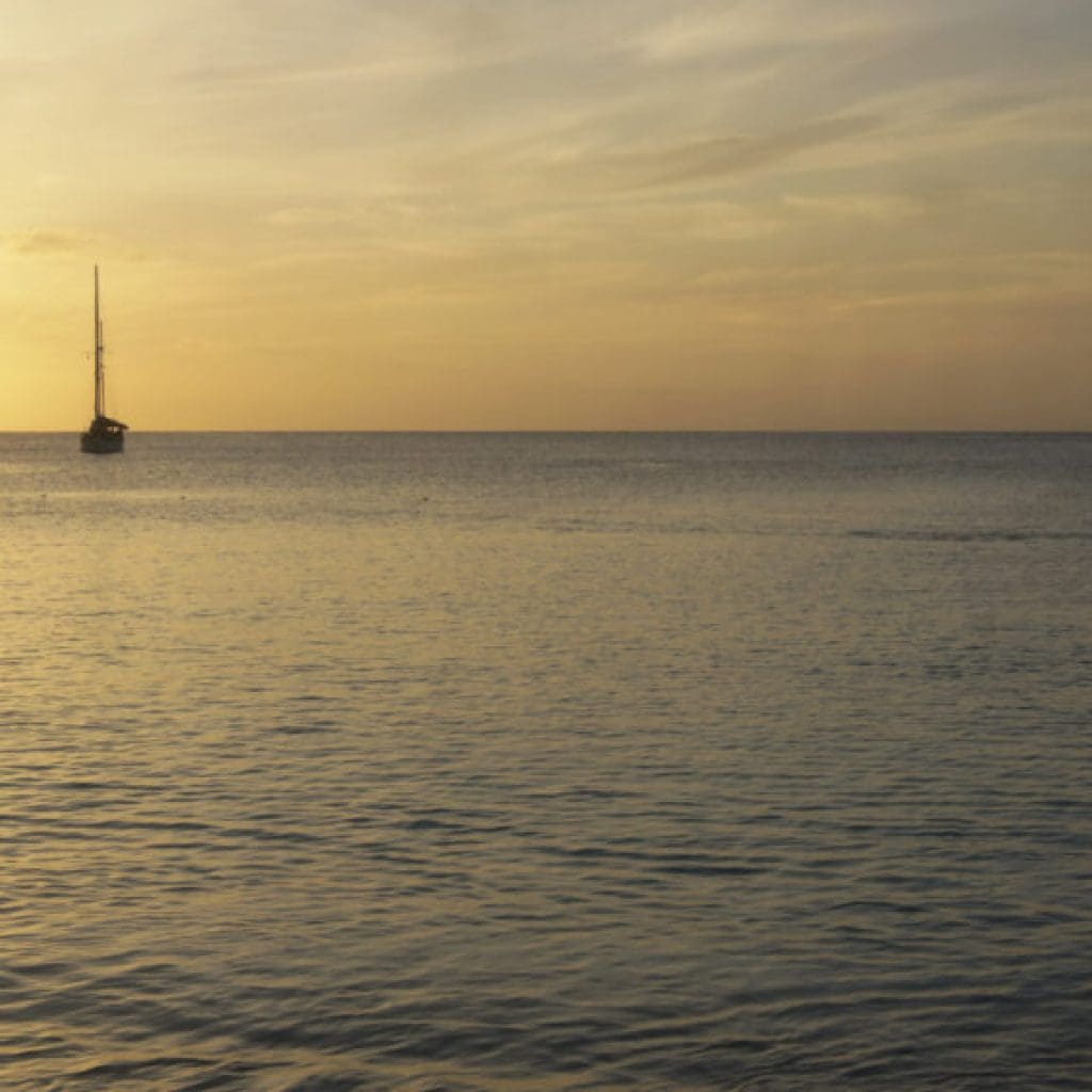 Traveler jumping on Grace bay beach at sunset
