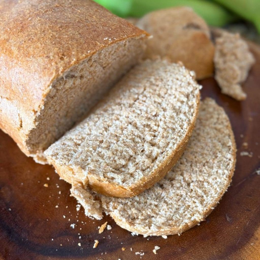 Freshly sliced homemade whole wheat bread on a wooden board.
