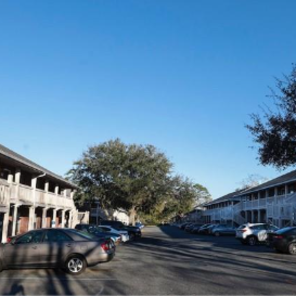A street lined with parked cars and buildings on a clear day.