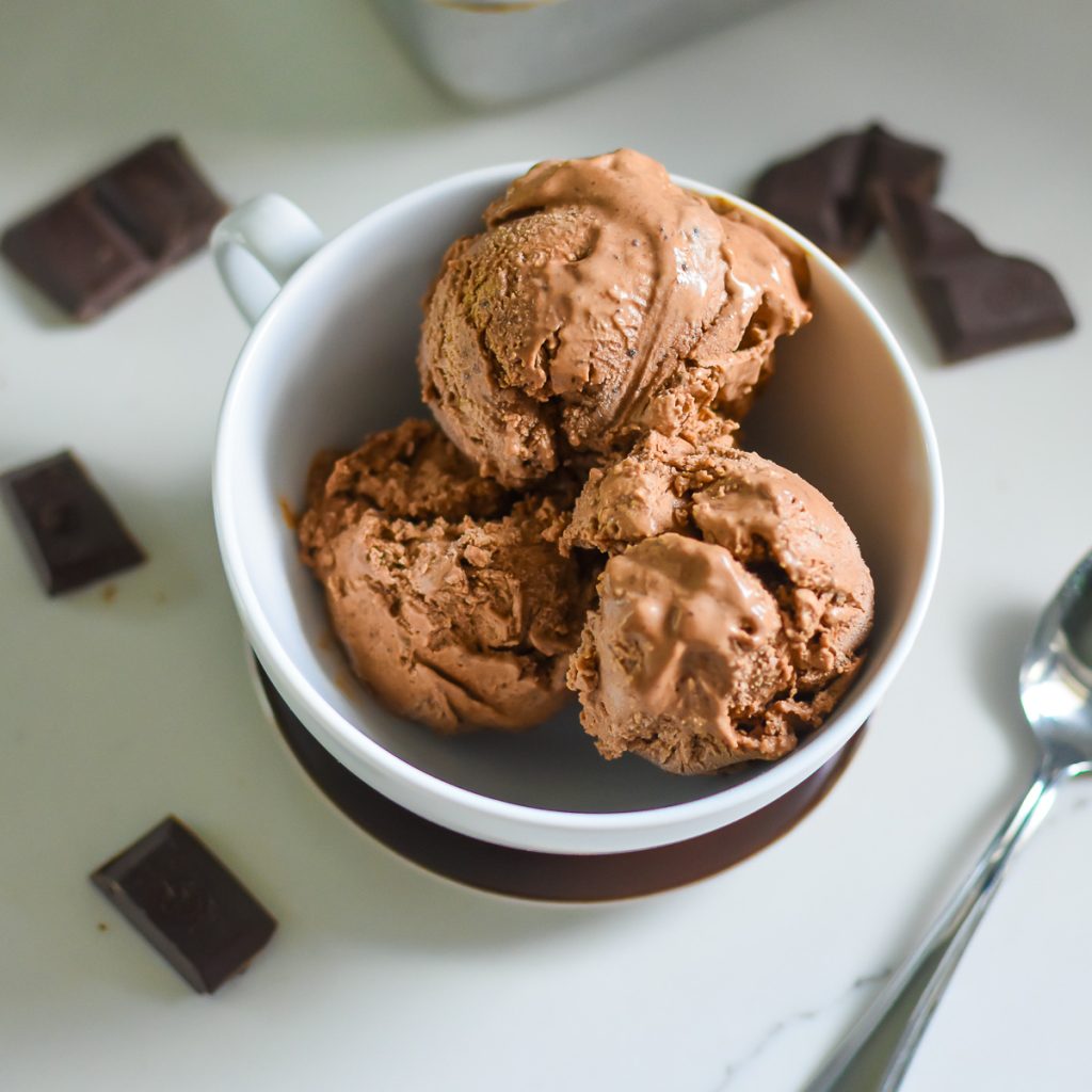 Homemade Dark Chocolate Ice Cream (No-Churn Recipe!) three scoops of the best dark chocolate ice cream made at home without an ice cream maker, served in a white bowl surrounded by broken dark chocolate bars.