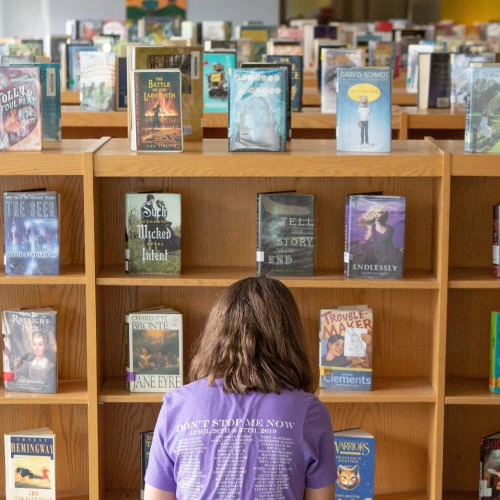 Student in front of rows of books