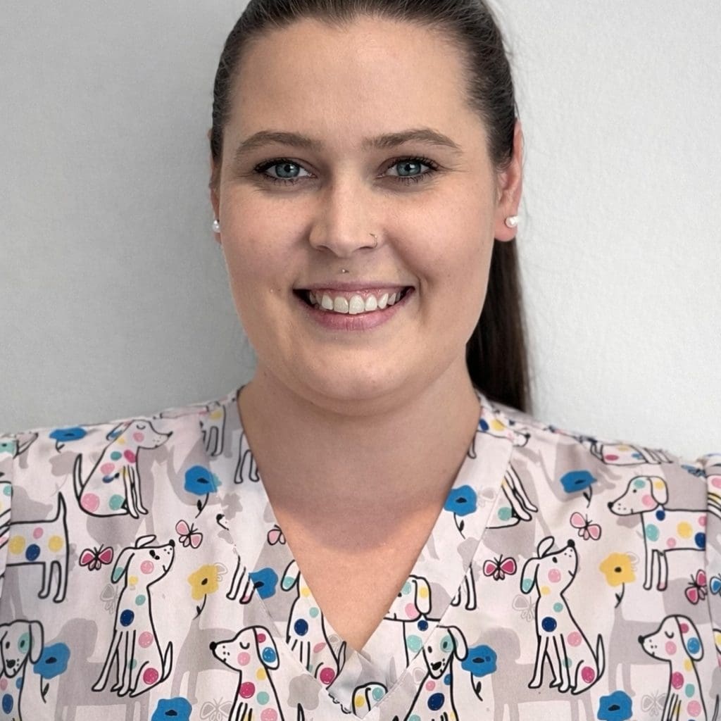 Desiree Love, a medication associate at The Residence at Fitz Farm and National Ceca Award finalist, is wearing dog-patterned scrubs and smiling.