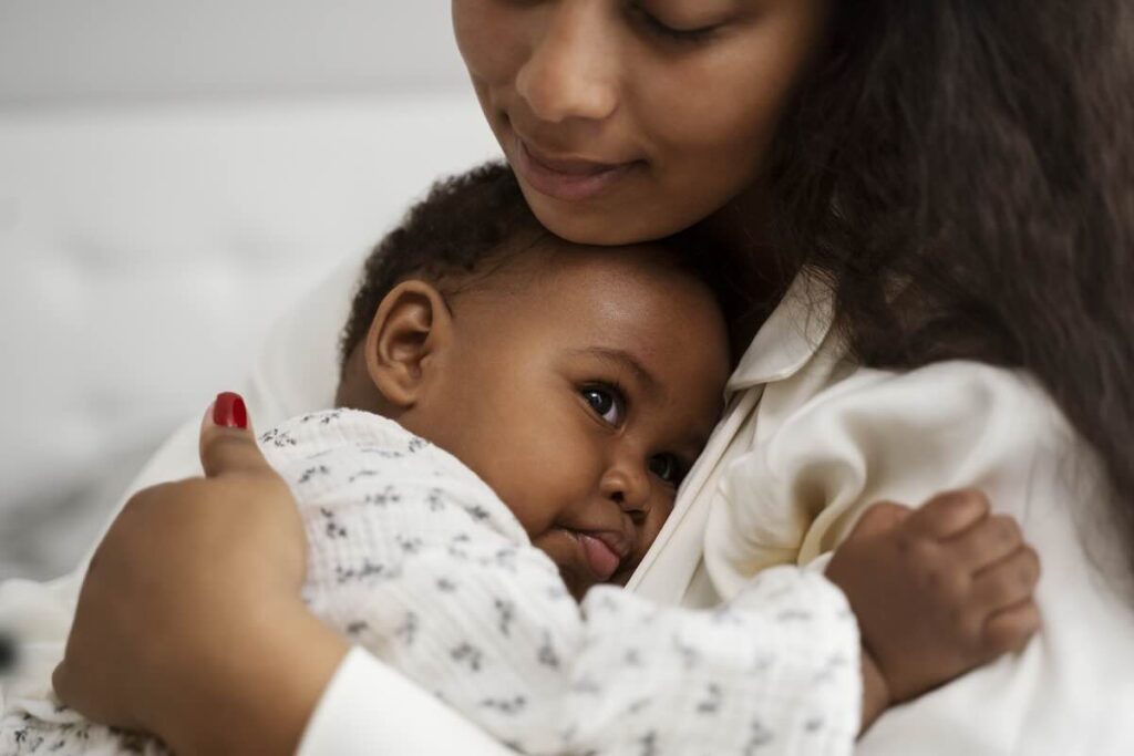 Black mother hugging her infant baby