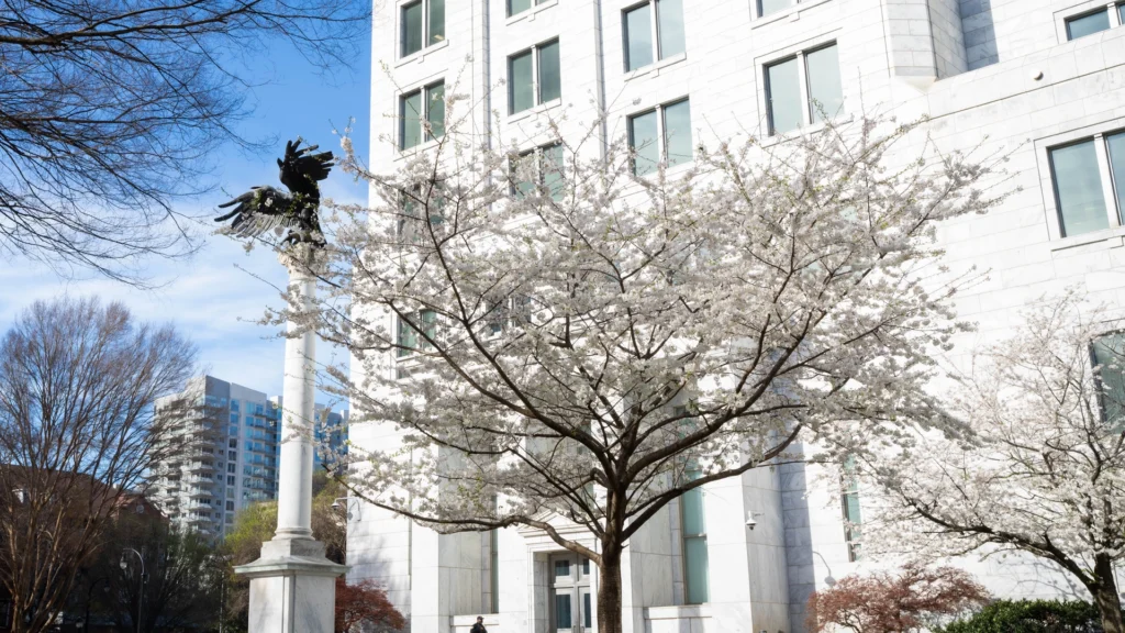 Atlanta Fed building from sidewalk with eagle statue and trees