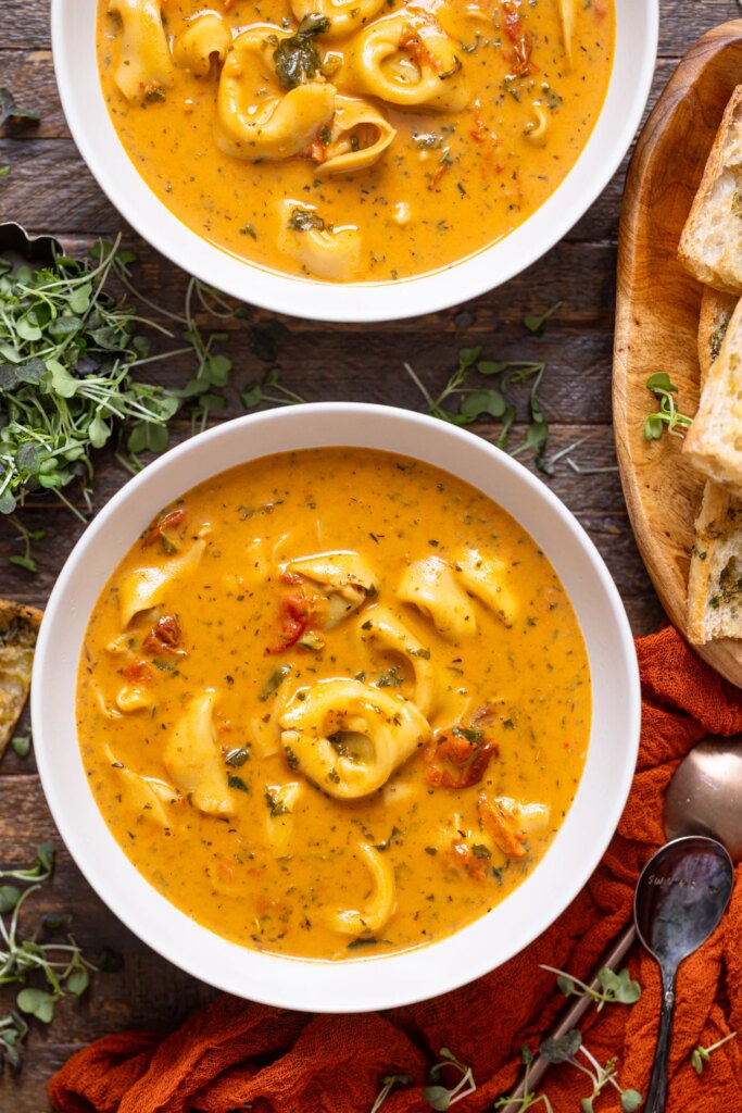 Two bowls of Creamy Tuscan Tortellini Soup [Easy + Comforting].