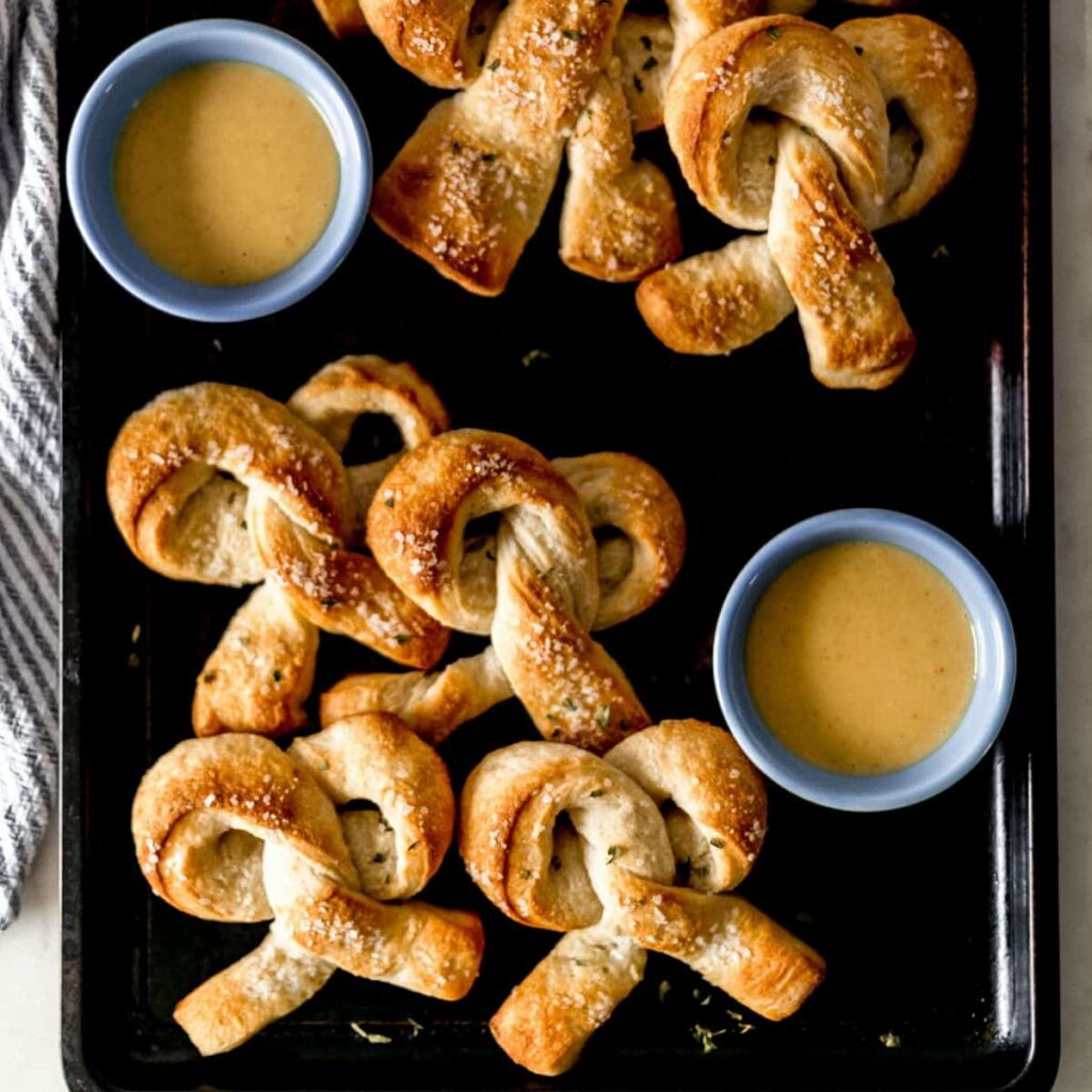 Soft Pretzels Recipe – Simply LaKita Two photos of finished pretzels on sheet pan on pin with text overlay.