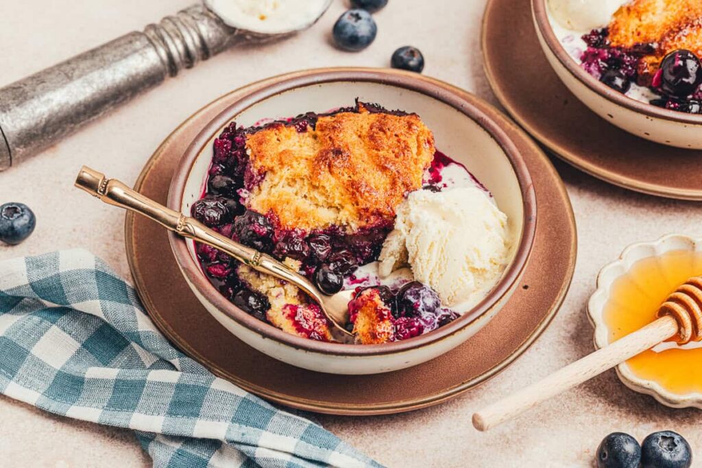 Honey Sweetened Blueberry Cobbler – A Classic Twist A plate with a serving of honey Sweetened blueberry cobbler.