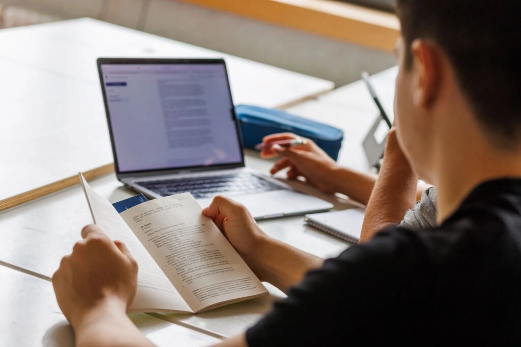 Norway Says AI Ain’t for Education A student points at a computer screen while writing