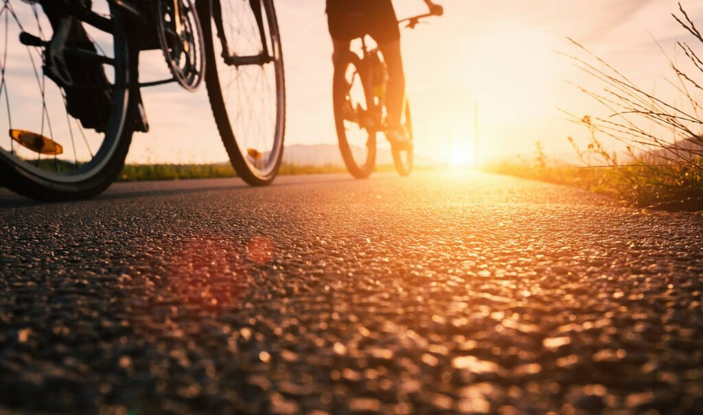 When to Worry About ‘Summer Slide’? Tips to Help Fight Real Learning Loss Rear view of two people riding bikes towards susnet