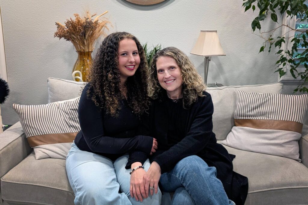 Screens are Leaving Schools Fast, Though Some Students with Disabilities Rely on Them A teenager with curly, brown hair sits next to her mother.