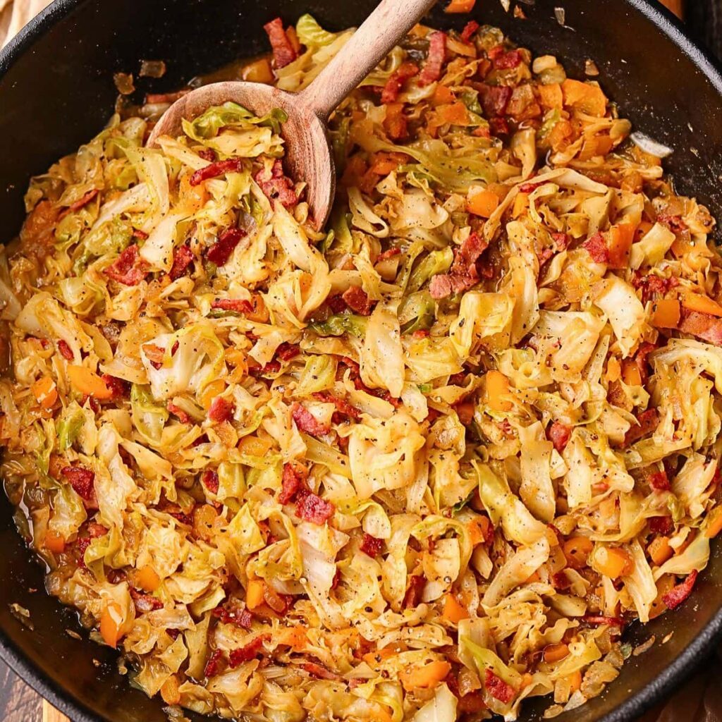 Southern Fried Cabbage with Bacon Southern fried cabbage with bacon in a skillet with serving spoon.