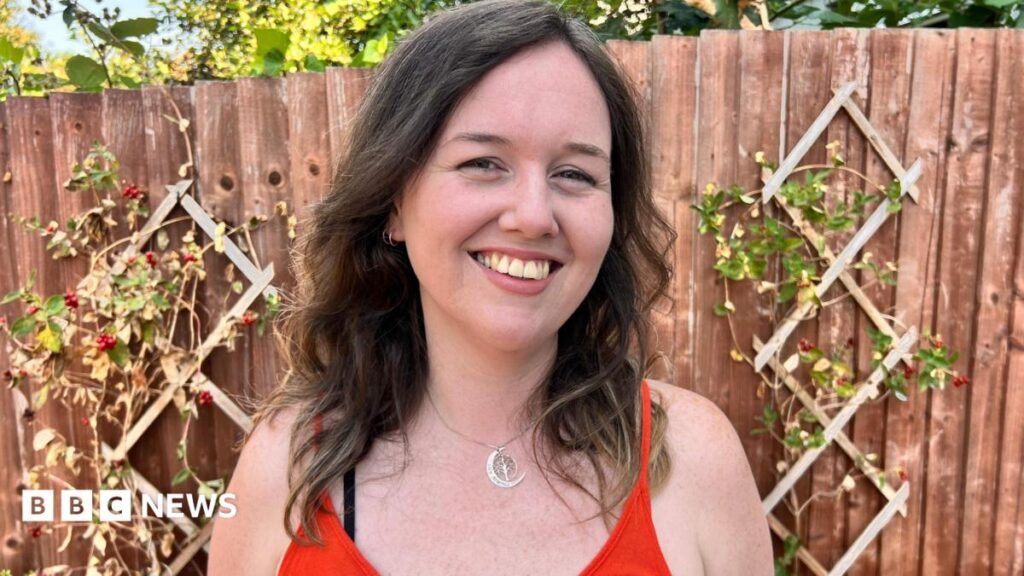 Heat anxiety: ‘This year has been the worst’ A white woman with brown hair smiles in the garden looking at the camera.
