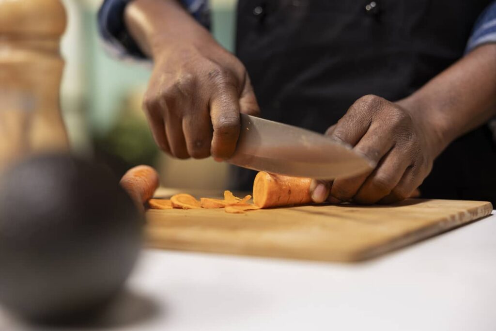 What to Look for in High Quality Knives Close up of man cutting carrots for a fresh salad