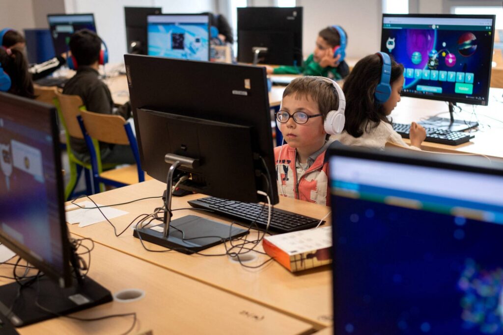 Student sits at desk in front of computer.