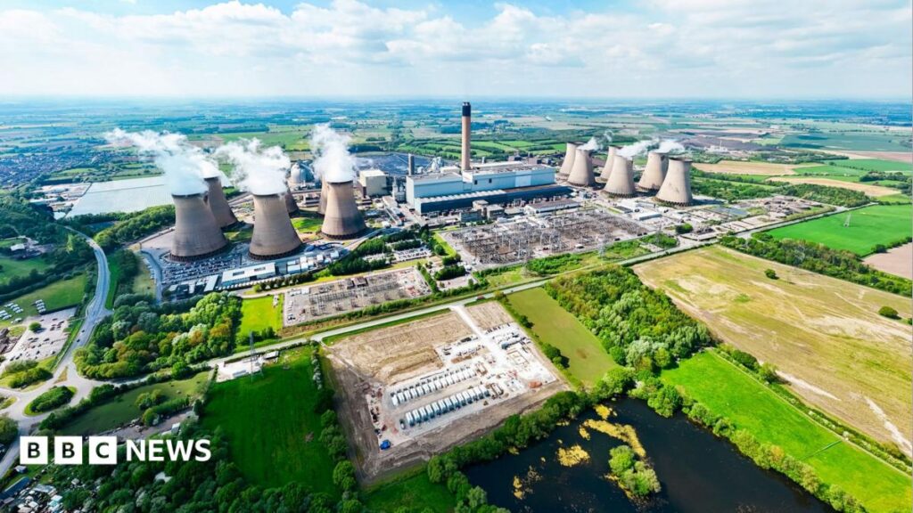 An aerial image of Drax power station showing several cooling towers set among a large site with buildings. The power station is surrounded by green land.