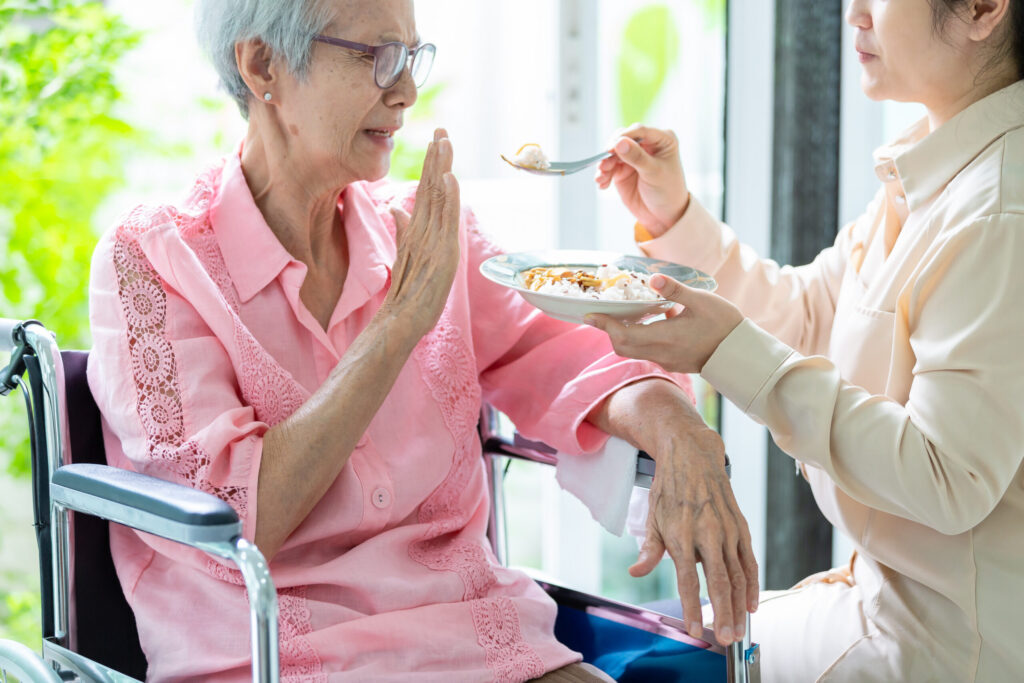 Appetite Loss in Seniors: Warning Signs & Ways to Help Senior woman refusing to eat food from her adult woman