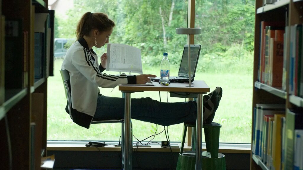 Are Med Students Cheating if They Use AI? A photo of a female college student studying in front of a window in a library.