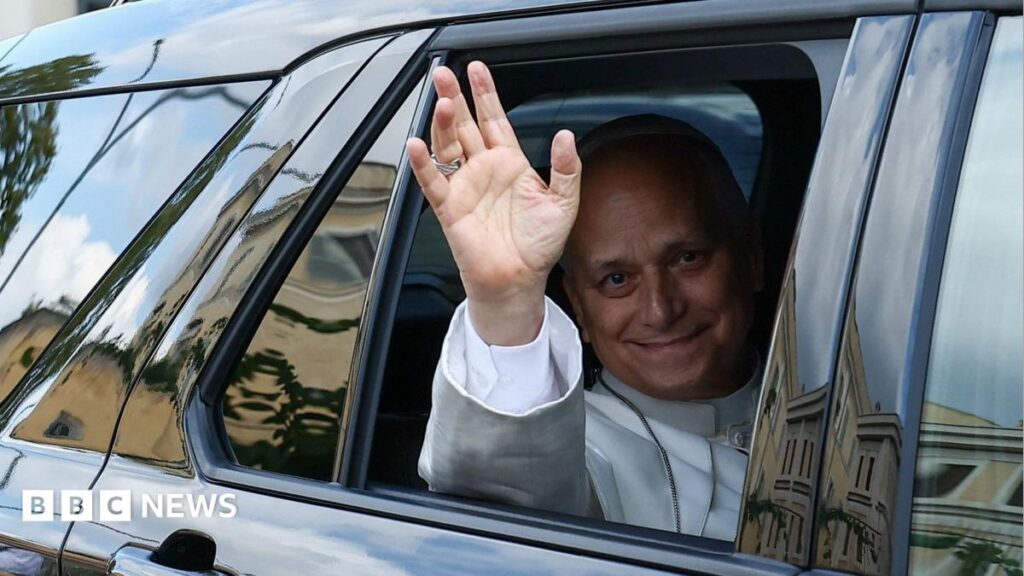Pope Leo XIV waves from the window of a car as he leaves Rome