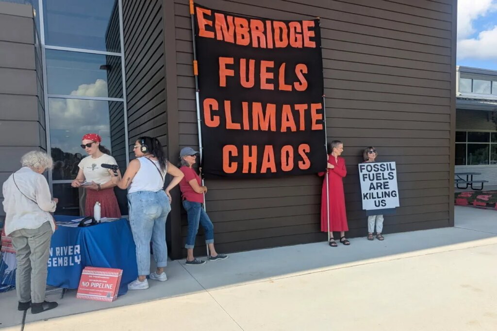 ‘We Are Seen as Disposable’: Rural Residents Fight a Proposed Gas Pipeline A group of people stand outside in protest. Two of them hold up a large sign that reads,